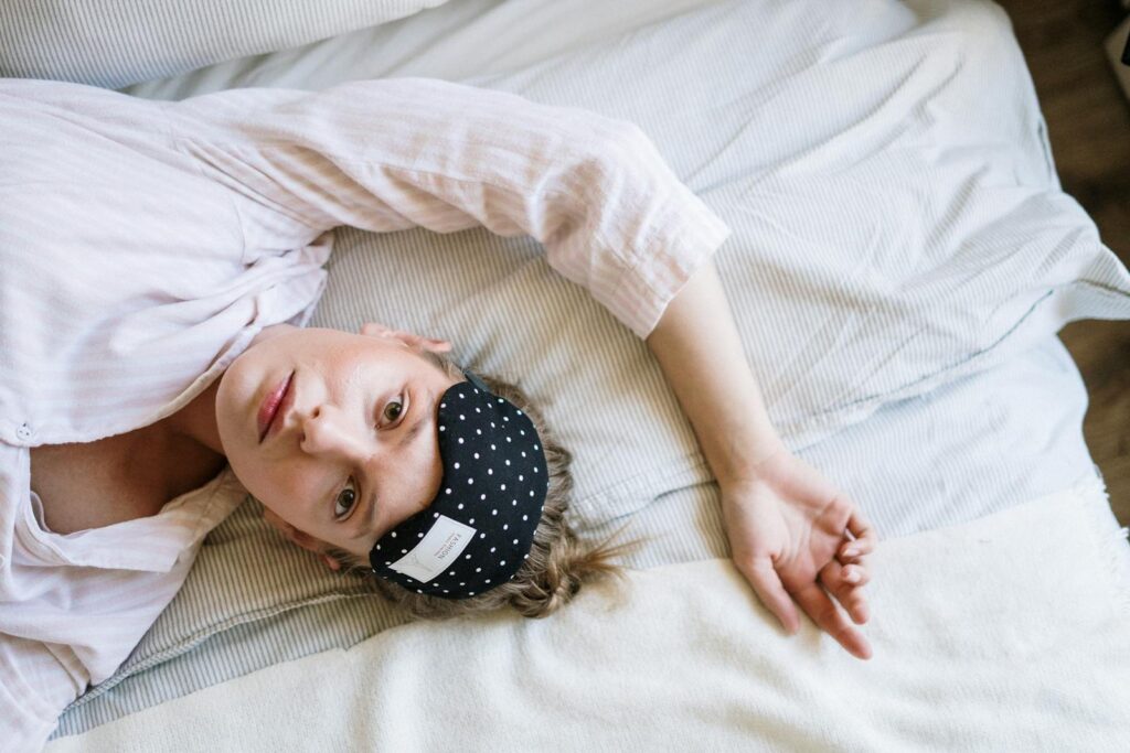 Woman in White Crew Neck T-shirt Lying on Bed