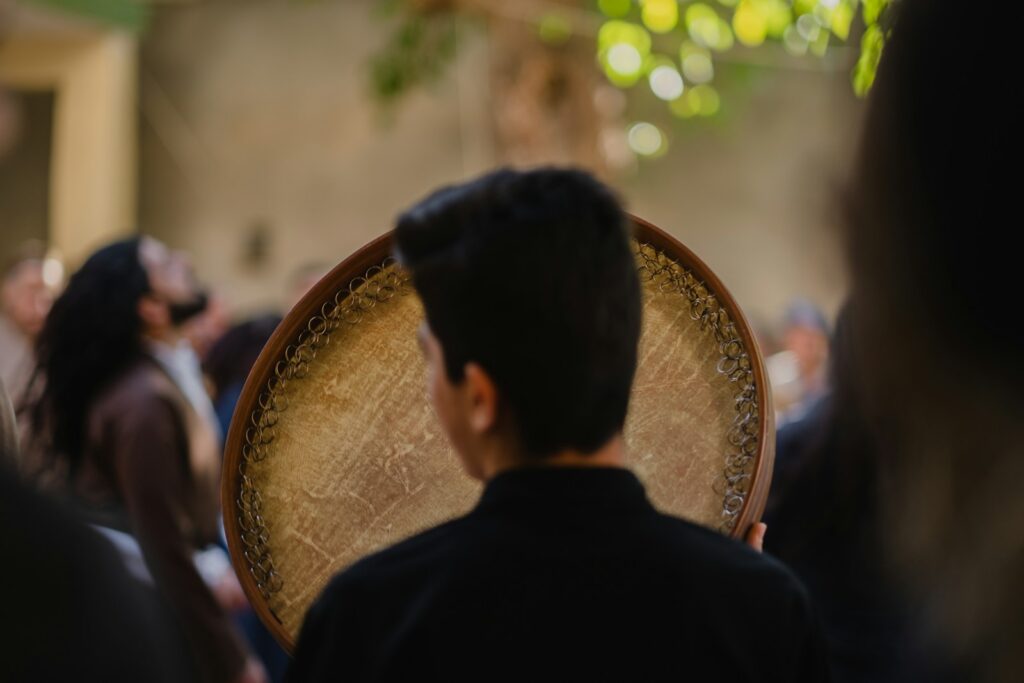 a man holding a wooden chair in front of a crowd